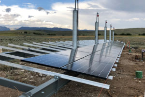 solar installer working on pole mount solar array
