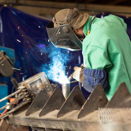 welder with sparks building solar mounts in USA