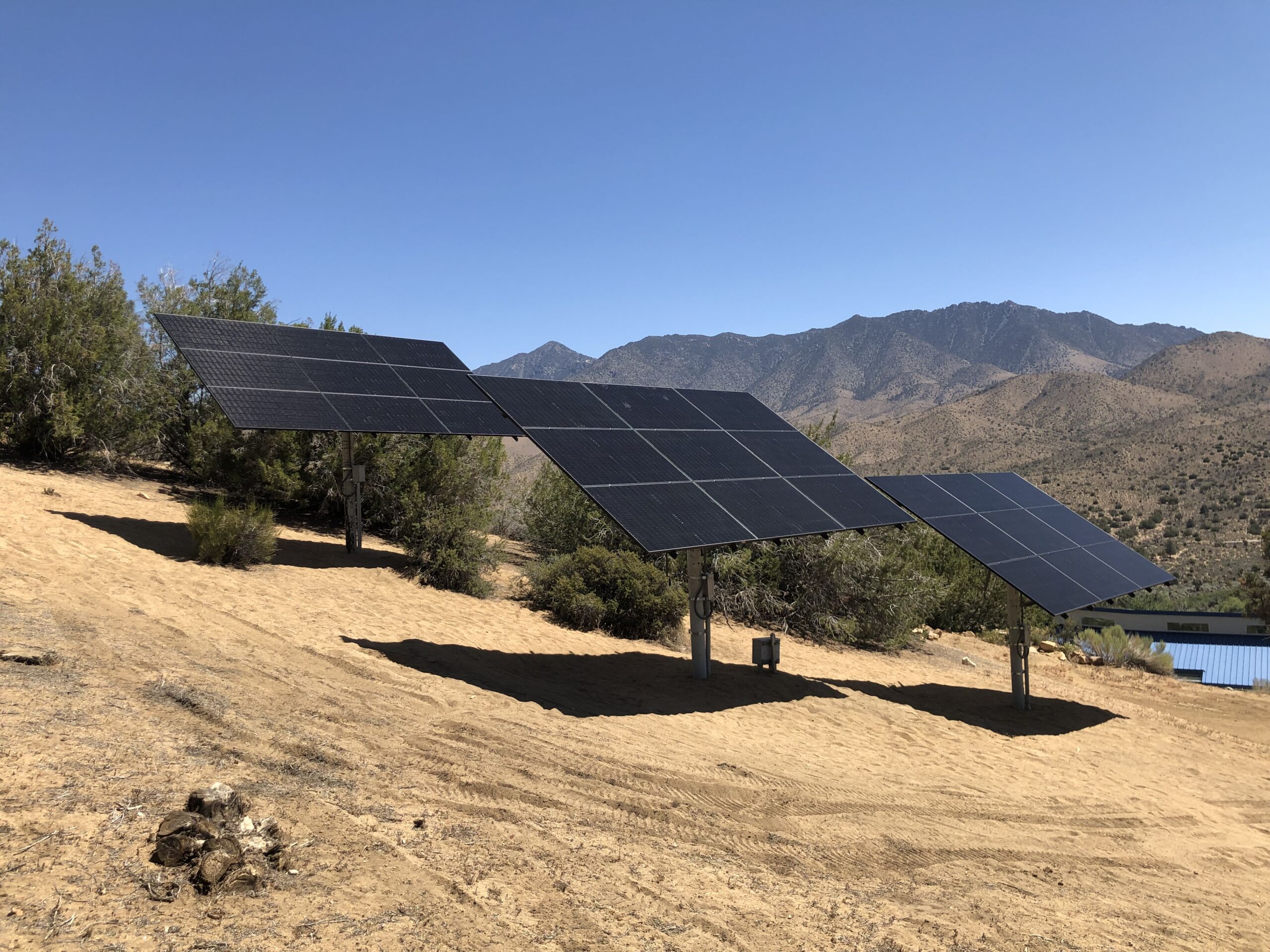three solar arrays in a sandy california desert.