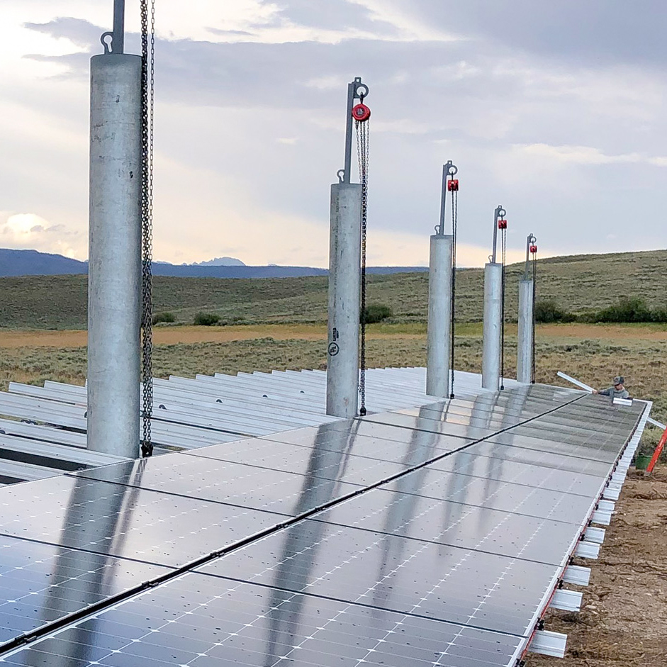installer placing solar modules on a ground mount in wyoming