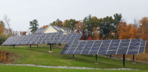 large pole mounted solar arrays on a grassy hill in autumn northeast USA