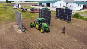 a tractor plants food seeds next to solar arrays