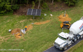 pole mount solar installation from above with concrete truck and installers