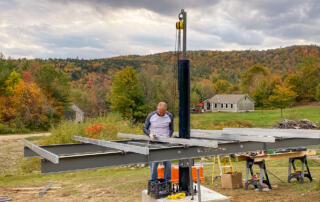 solar installer placing tamarack rails on mt solar mount with fall forest