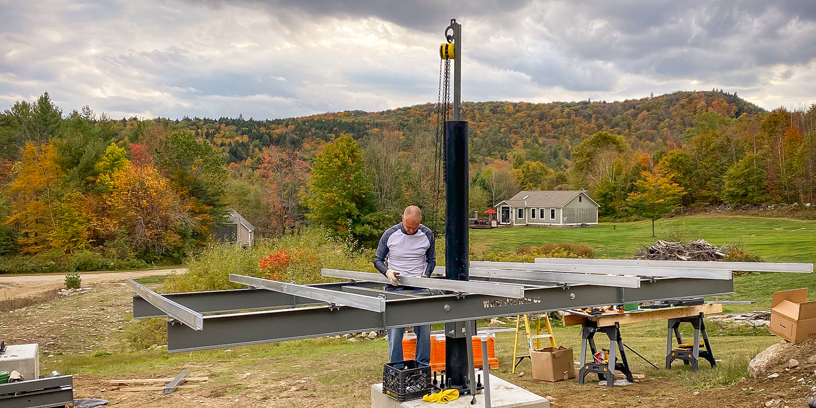 solar installer placing tamarack rails on mt solar mount with fall forest