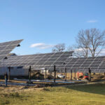 commercial-golf-course crew adjusting the tilt angle of large solar arrays with high ground clearance